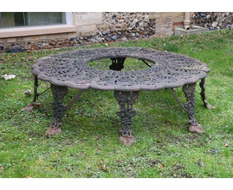 A Victorian style cast iron tree seat, 20th century, the shaped seat decorated with repeating floral motif raised on vine and