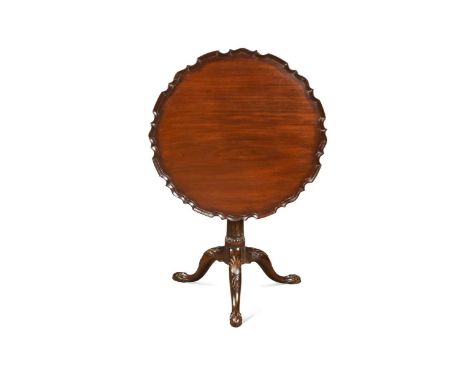 A George III mahogany pie crust tripod table, the circular top with scalloped edge upon a birdcage action tilt-top with a flu