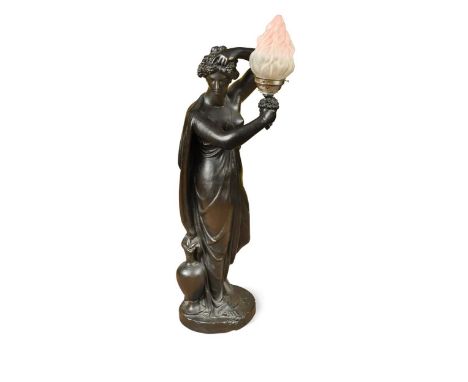 A black painted plaster figure, 20th century,  the goddess Demeter holding a torch, modelled as a floor lamp, with glass shad