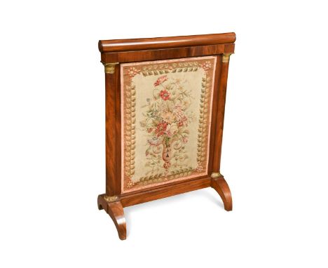 An Empire mahogany fire screen, the needle-work panel depicting a bouquet of flowers within a leafy border between brass moun