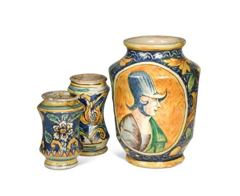 An Italian albarello, circa 1700,  the blue ground body decorated with scrolling foliage and reserved with an oval panel pain