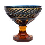 An amber and blue flashed pedestal bowl with cut decoration, 25cm diameter.