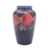 A Walter Moorcroft pottery vase of oviform, tube lined in the Pomegranate pattern on a blue ground,
