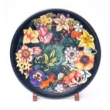 A Moorcroft pottery charger tube lined in the Carousel pattern after the original by Rachel Bishop,