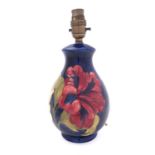 A Walter Moorcroft pottery lamp base, tube lined in the Hibiscus pattern,