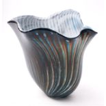 A cased art glass vase of flaring form with arbitrary rim the exterior with wrythen vertical bands