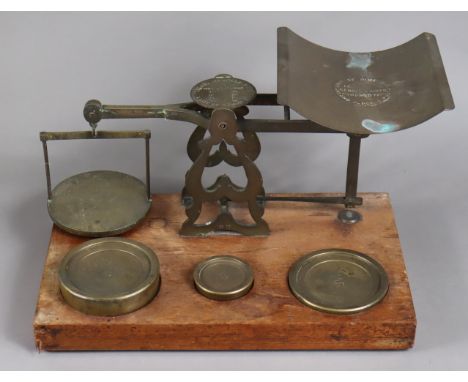 A large set of brass postal scales to weigh up to 71lbs, with brass weights, &amp; mounted on a mahogany plinth base.