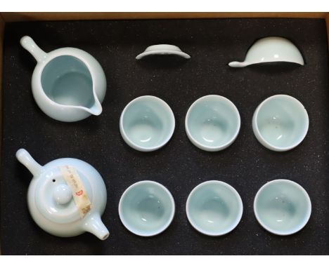 A Chinese celadon glazed pottery ten-piece child’s tea service cased; two celluloid dolls; &amp; various items of dolls cloth