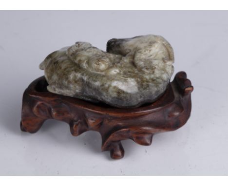 Russet jade carving of a boy on an ox Chinese carved depicting the ox in a recumbent position with the boy lying on top of th
