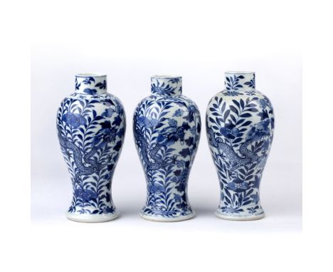 Group of three blue and white porcelain vases Chinese, 19th Century each with dragon designs and Kangxi marks, 22.5cm high Co