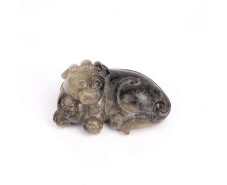 Black and grey jade scroll weight Chinese, Ming period (16th/17th Century) carved as a recumbent mythical beast, triple horne