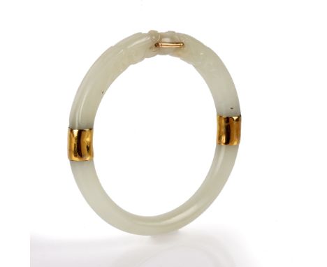 Carved jadeite bangle Chinese with two animal heads meeting in the middle, with yellow coloured mounts, 7cm across Condition: