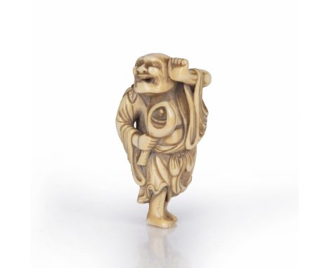 Ivory netsuke of a standing Sennin Japanese, 18th Century Kyoto School holding a lotus bud within which an Immortal squats re