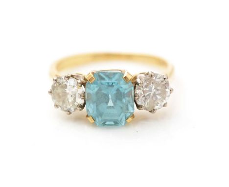 A topaz and diamond ring, the central canted rectangular light blue topaz measuring 8.2 x 7.0 x 5.4mm, flanked by two brillia