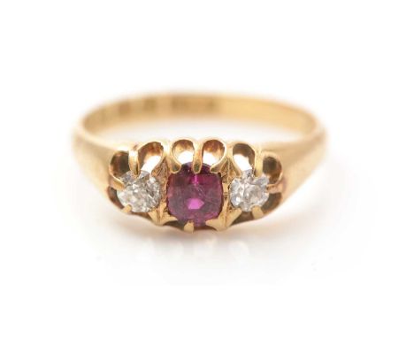 An Edwardian ruby and diamond ring, the central oval facet cut ruby measuring approximately 5.0 x 4.3 x 3.2mm, flanked by a p