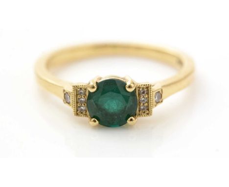 An emerald and diamond ring, the circular facet cut emerald measuring 6.4 x 6.4 x 4.1mm estimated to weigh 0.8carats, flanked