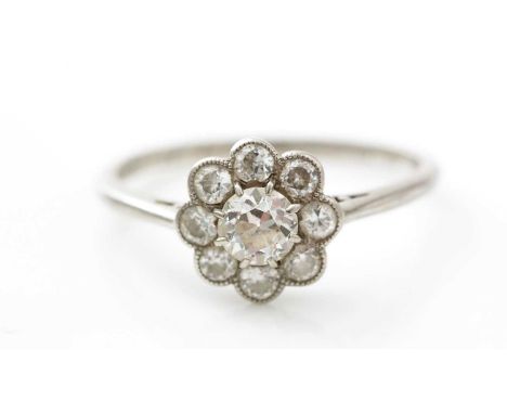 An early 20th Century diamond cluster ring, the nine brilliant cut diamonds weighing a total of approximately 0.90carats, in 