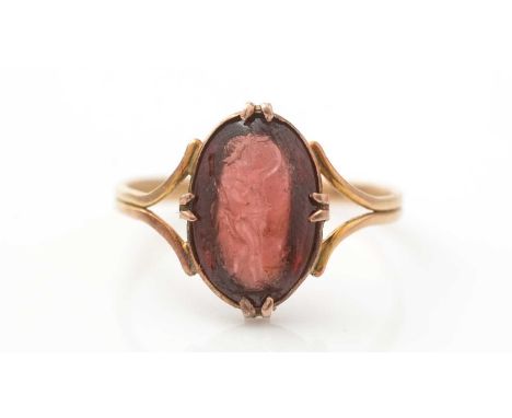 A 19th Century Grand Tour carved garnet intaglio ring, the oval intaglio of a male classical figure, 18ct yellow gold mount a