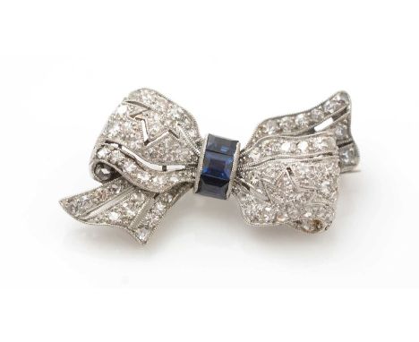 An Edwardian sapphire and diamond bow pattern brooch, the centre set with three rectangular step-cut sapphires, flanked by pa