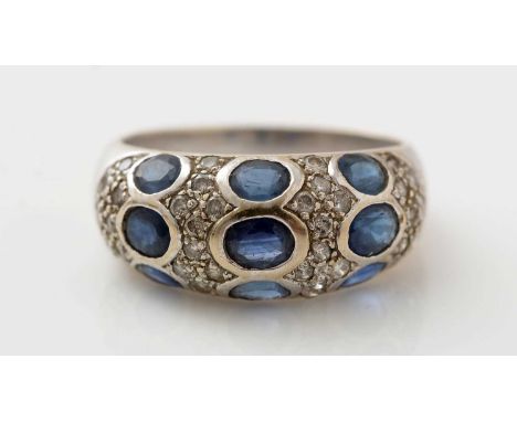 A sapphire and diamond ring, of bombe form set with nine graduated oval facet cut sapphires surrounded by pave set diamonds, 