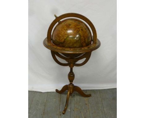 A reproduction terrestrial globe on baluster stand with three outswept legs