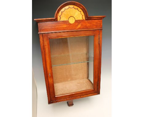 A MAHOGANY GLAZED HANGING DISPLAY CABINET, the top with a central arch inlaid with satinwood, single glazed door below, glass