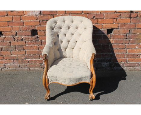 A VICTORIAN MAHOGANY FRAMED GENTLEMAN'S ARMCHAIR, button backed upholstery, raised on carved supports and brass castors