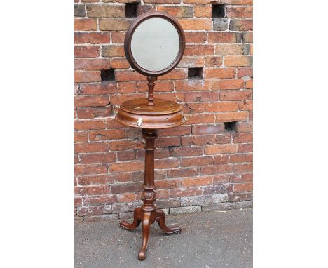 A MID VICTORIAN MAHOGANY SHAVING STAND, with a framed circular mirror held on an adjustable brass support, a mid tier with co