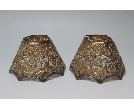 A PAIR OF HALLMARKED SILVER GILT PIERCED TABLE LAMP SHADES BY WILLIAM COMYNS - LONDON 1894 - intricately detailed with mythic