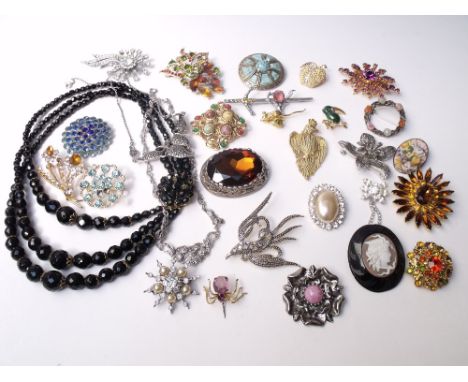 A COLLECTION OF VINTAGE COSTUME JEWELLERY, comprising mostly brooches, including signed examples by 'Miracle', and a carved j