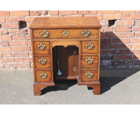 A GEORGIAN MAHOGANY KNEEHOLE DESK OF SMALL PROPORTIONS, having a long frieze drawer above six graduated pedestal drawers, the