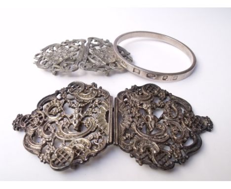 A MODERN HALLMARKED SILVER BANGLE - LONDON 2003, together with two silver plated nurses belt buckles, the larger buckle of or