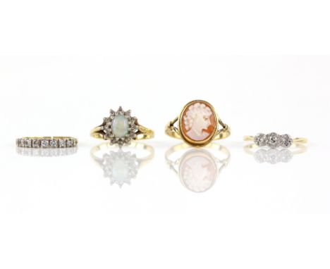 Four gem set rings, one illusion set three stone, size M, another diamond half eternity, size I, opal and diamond cluster rin