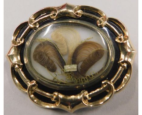 A Victorian memorial brooch, with central memorial panel, with locket of hair, surrounded by black enamel, in yellow metal fr