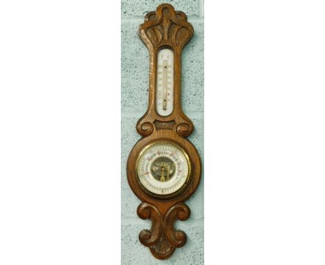 An early 20thC carved oak aneroid barometer, with thermometer, 54cm high