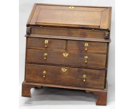 An 18thC oak bureau, the fall with a moulded edge, enclosing a fitted interior with a well above an arrangement of two short 