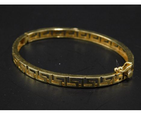 An Aztec design pierced hinged bangle, yellow metal, marked 585, 9.7g all in. 