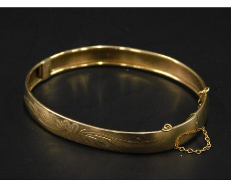 A 9ct gold bangle, with design of engraved flowers and leaves, 10.2g.