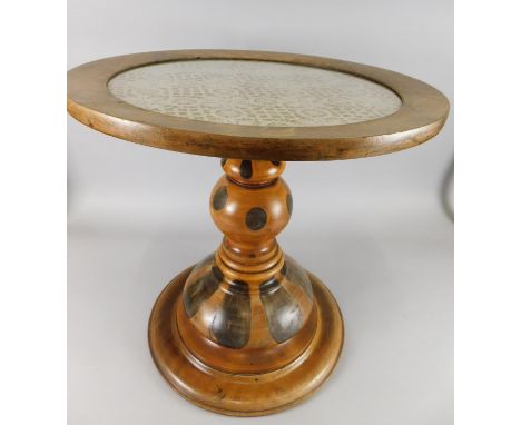 A Continental mahogany occasional table, the circular top inset with lace panel, on oyster style decorated turned column, the
