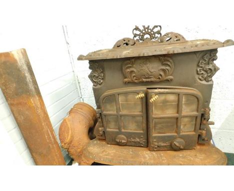 A large cast iron stove, labelled ESSE, the glazed doors with brass swivel handles, sold with some pipe etc.