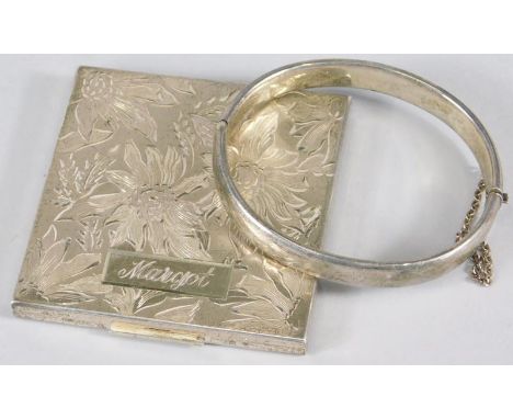 An Elgin plated metal powder compact, decorated with flowers, engraved to the rectangular tablet shaped cartouche Margot, and