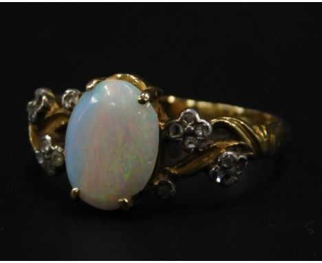 An 18ct gold opal and diamond dress ring, set with central opal, with wavy design arms, set with flowers, each with tiny diam