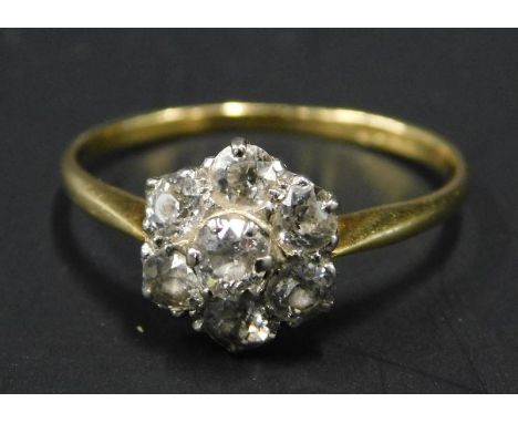 A diamond floral cluster ring, set with seven stones, each stone approx 0.1cts, on a yellow metal band, with rubbed 'ct' stam