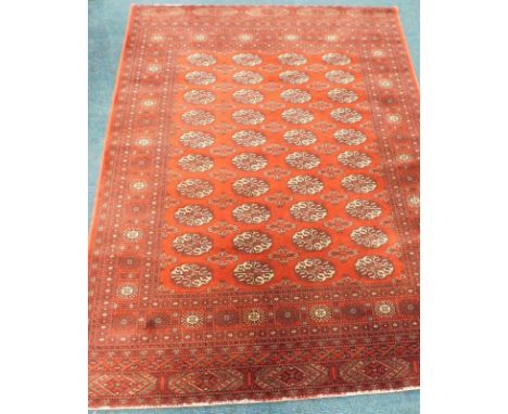 A modern Keshan wool carpet, decorated with four rows of medallions, on a red ground