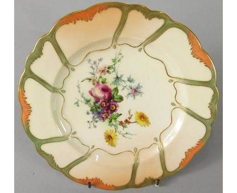 A Royal Worcester porcelain plate, painted centrally with flowers on a blush ivory ground, the shaped border picked out in gi