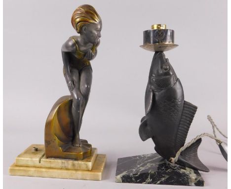 Two Art Deco style lamp bases, to include a figural example of a bathing girl beside a wave, on a marble base and a fish, pos