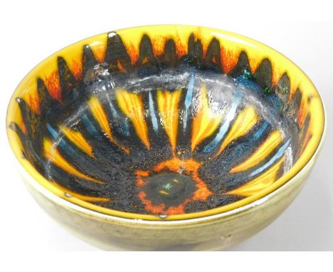 A Poole pottery Delphis style bowl, decorated centrally in orange, yellow, pale blue, black etc. (AF), 18cm dia.