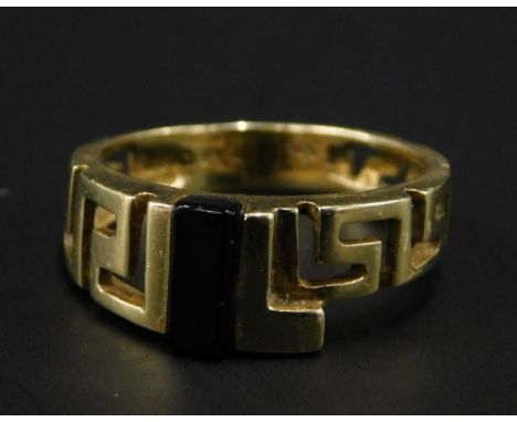 An abstract dress ring, of pierced Greek design, set to centre with black stone, yellow metal, marked 585, 3.5g all in. 