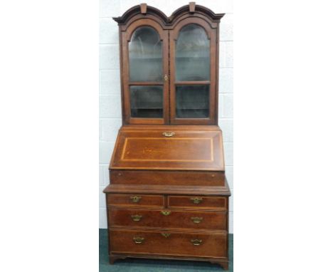A 19thC Queen Anne design oak bureau bookcase, the upper section with double dome top, above glazed doors, the base with fall