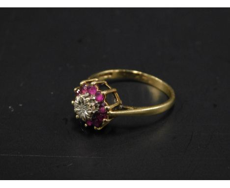 A 9ct gold dress ring, set in a floral cluster with illusion set white stone, surrounded by pink stones, 2.5g all in. 